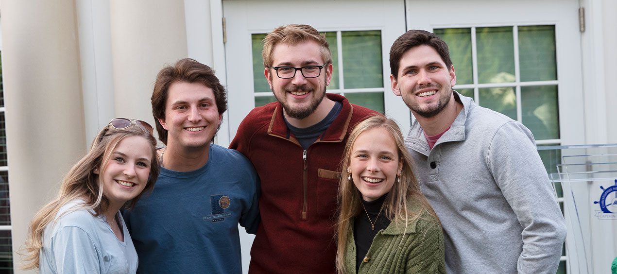 Group of alumni standing in front of the Klich Alumni House