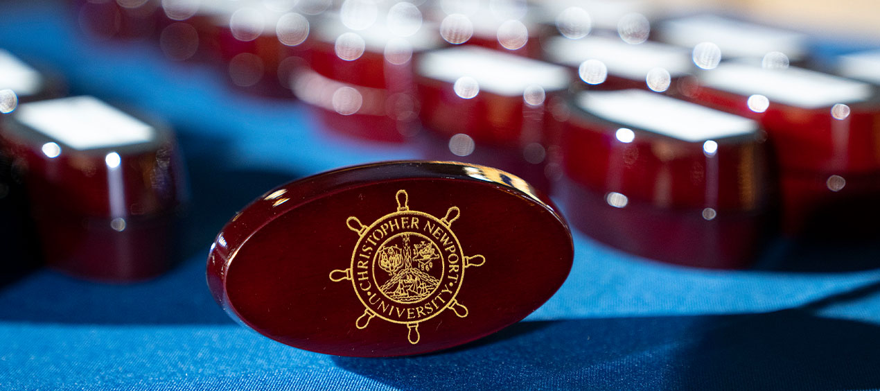 The back of a CNU class ring box featuring the ship wheel university seal